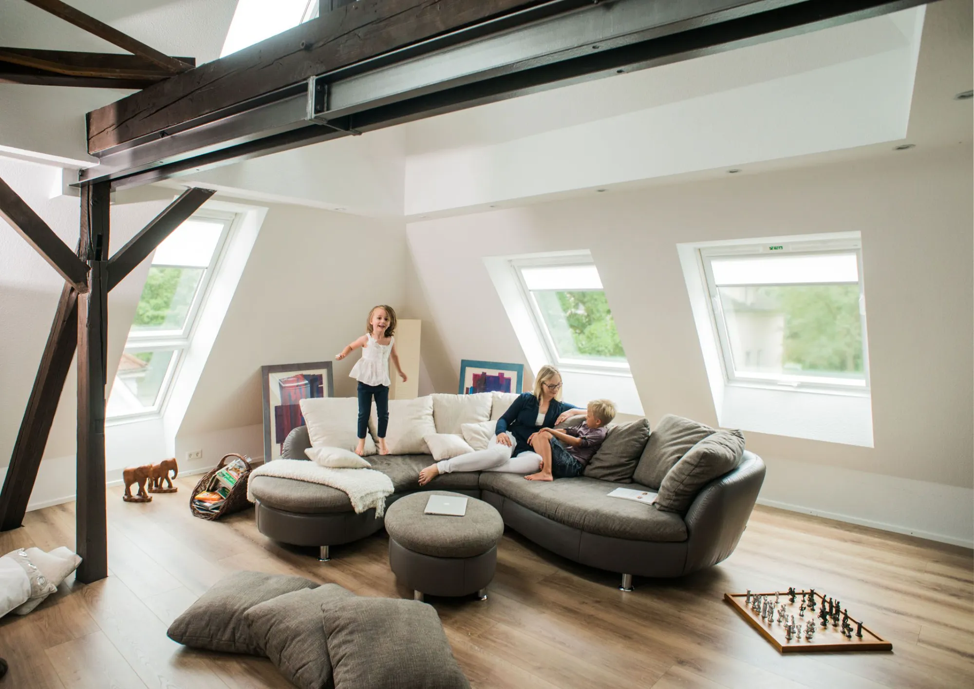 A group of people sitting on top of a couch in a living room.