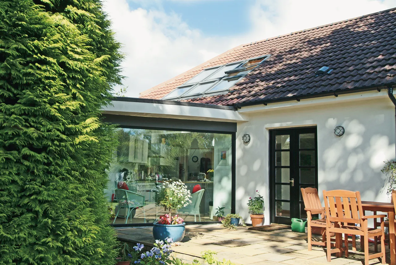 A patio with a table and chairs next to a house.