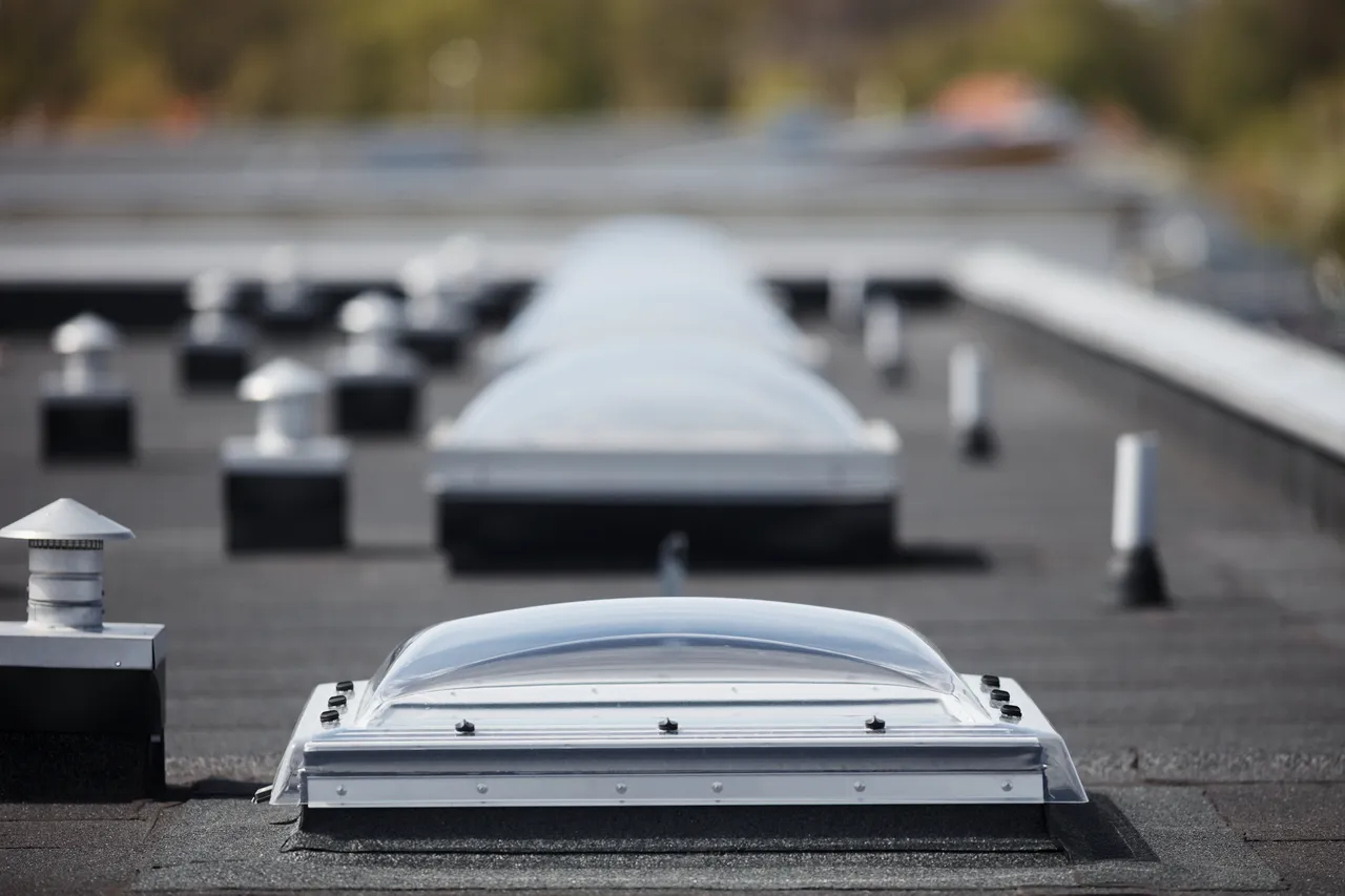 A row of flat roof vents on a building.