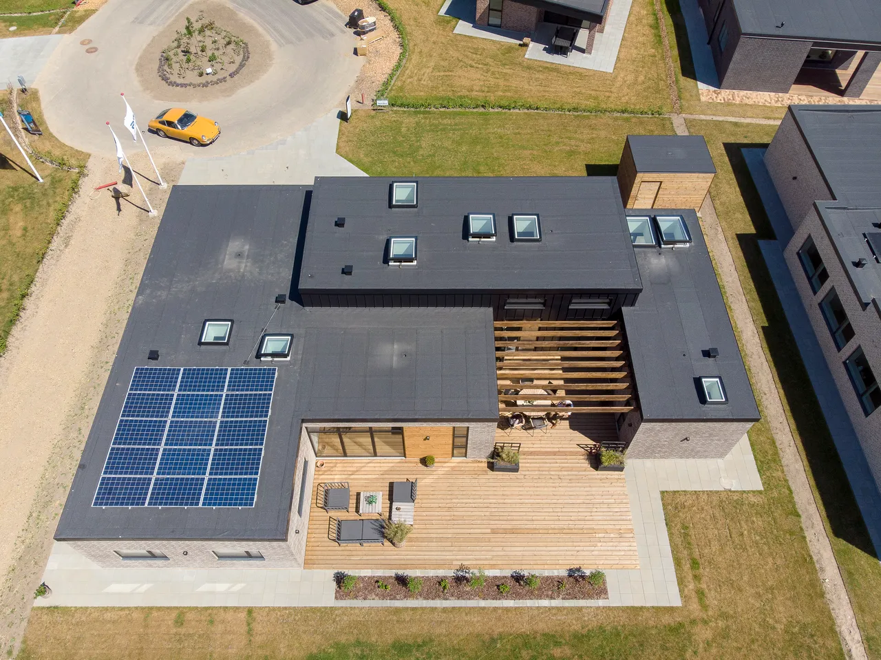 An aerial view of a house with solar panels on the roof.
