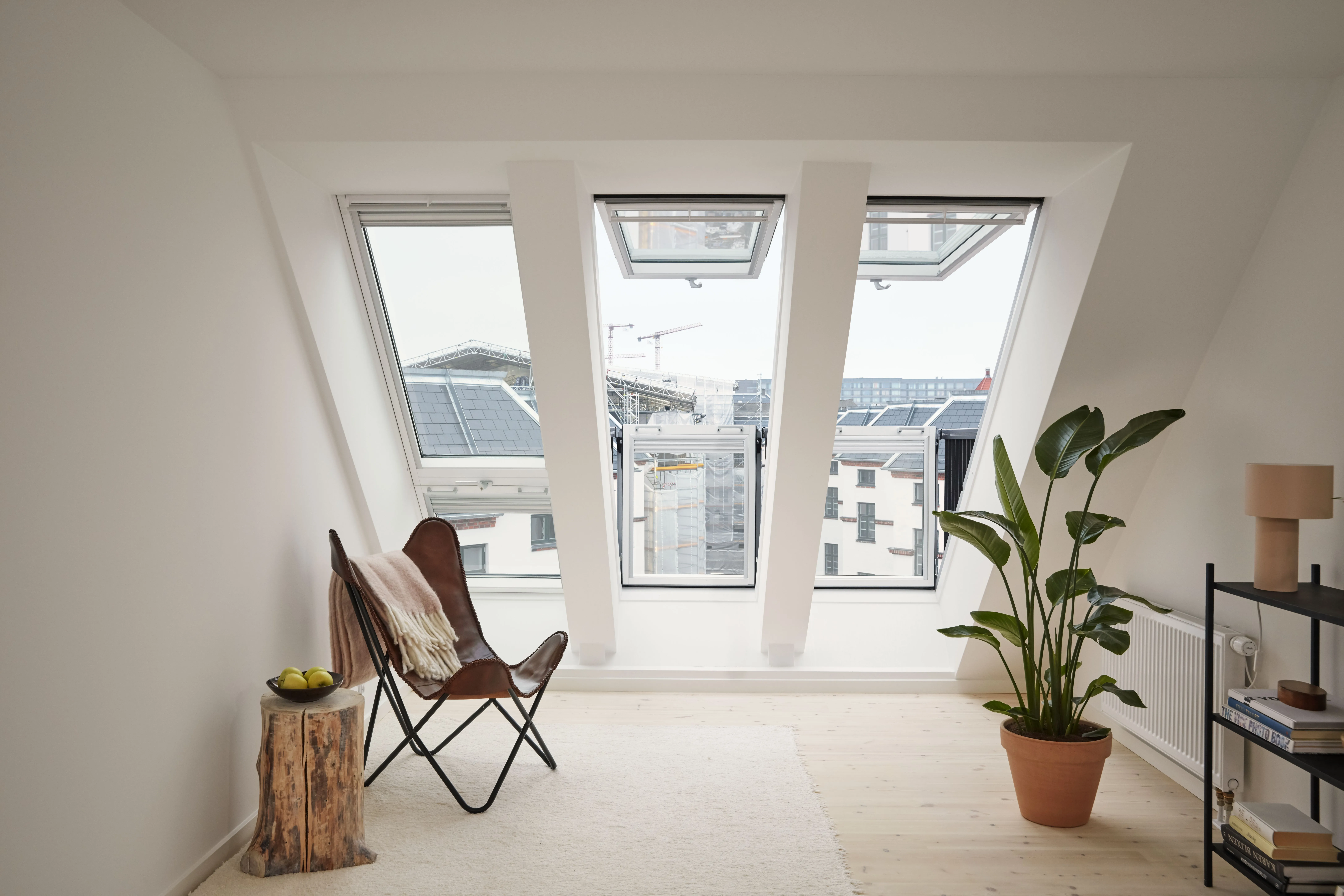 A room with a chair and a potted plant.